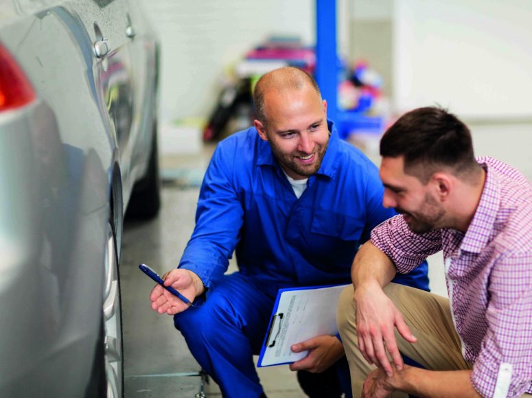 Mechaniker und Kunden besprechen Herstellergarantie beibehalten bei TOP Markenspezialist Autohaus Machel. Spezialist für Renault und Dacia